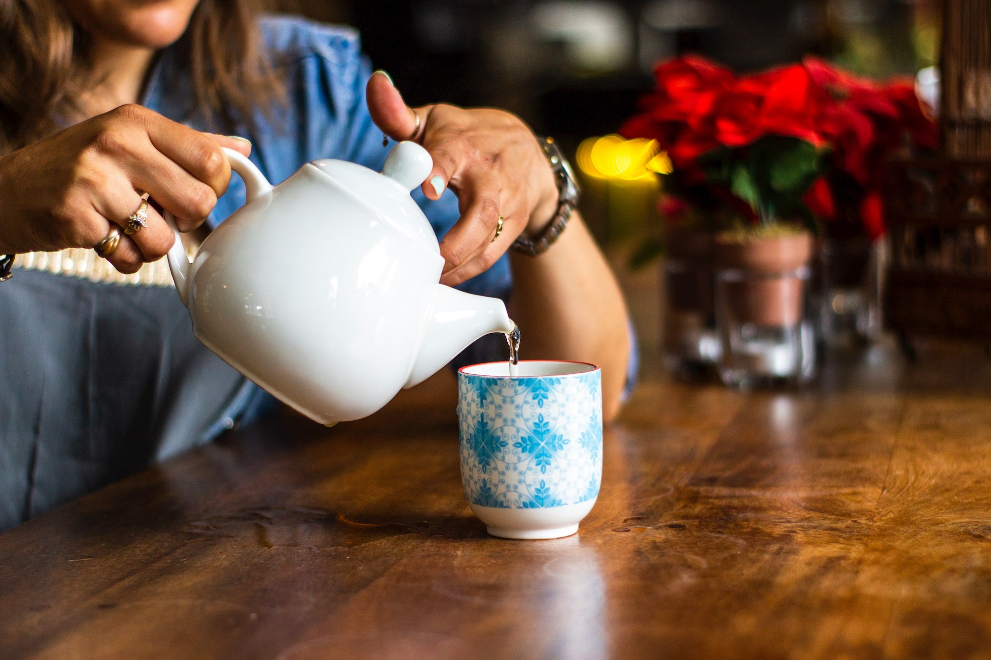 A local-expert from chester-based estate agency Currans Homes pours a cup of tea from a white teapot into a patterned cup for a potential lettings client on the search for the 'right' Chester-based letting agent.